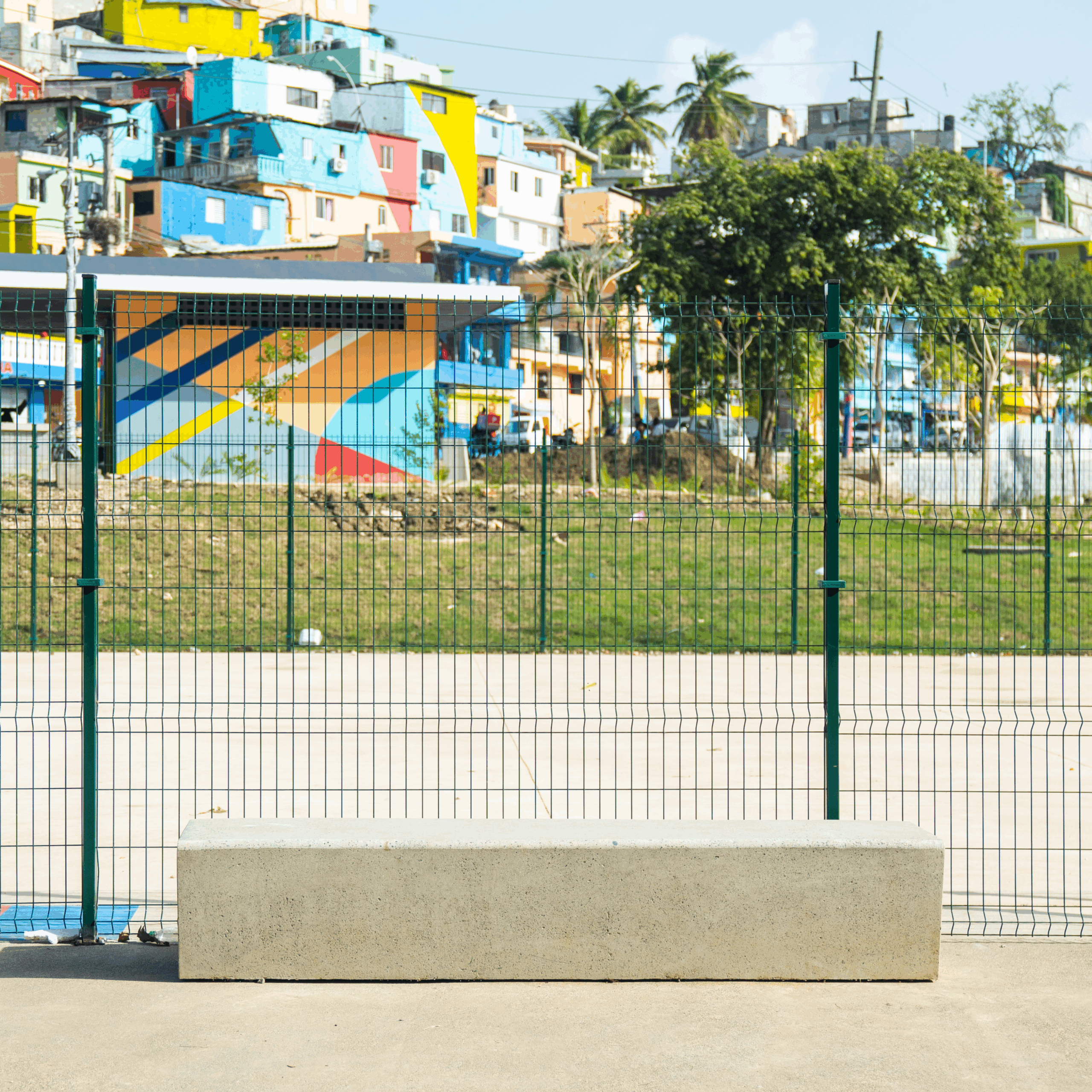 "Espacio público que conecta barrios mediante mobiliario urbano de Gola Urbano: jardineras, bancos y basureros"
