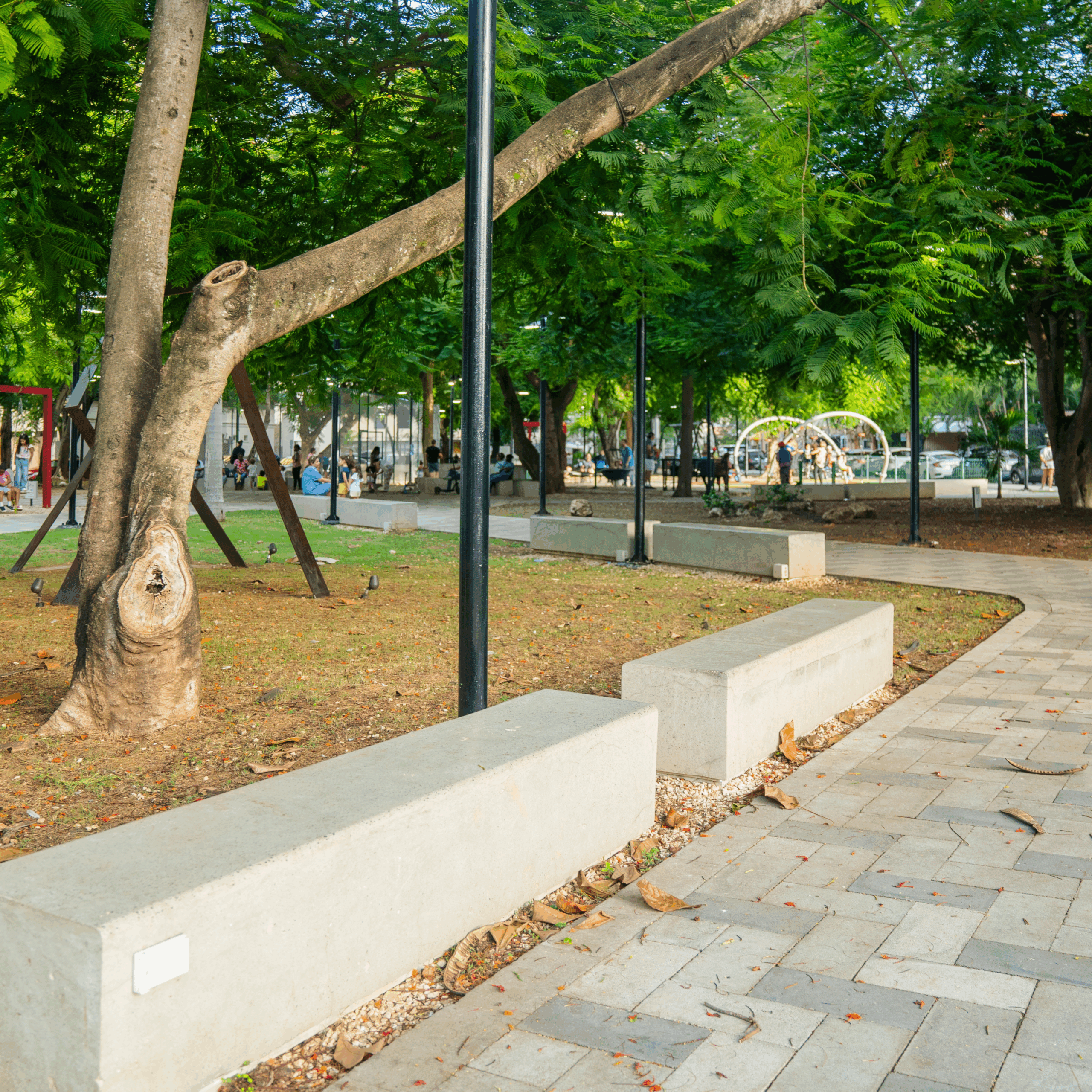 "Mobiliario urbano resistente en parque familiar con áreas de recreación y descanso"